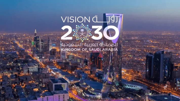 The Saudi Vision 2030 emblem over the Riyadh skyline at night